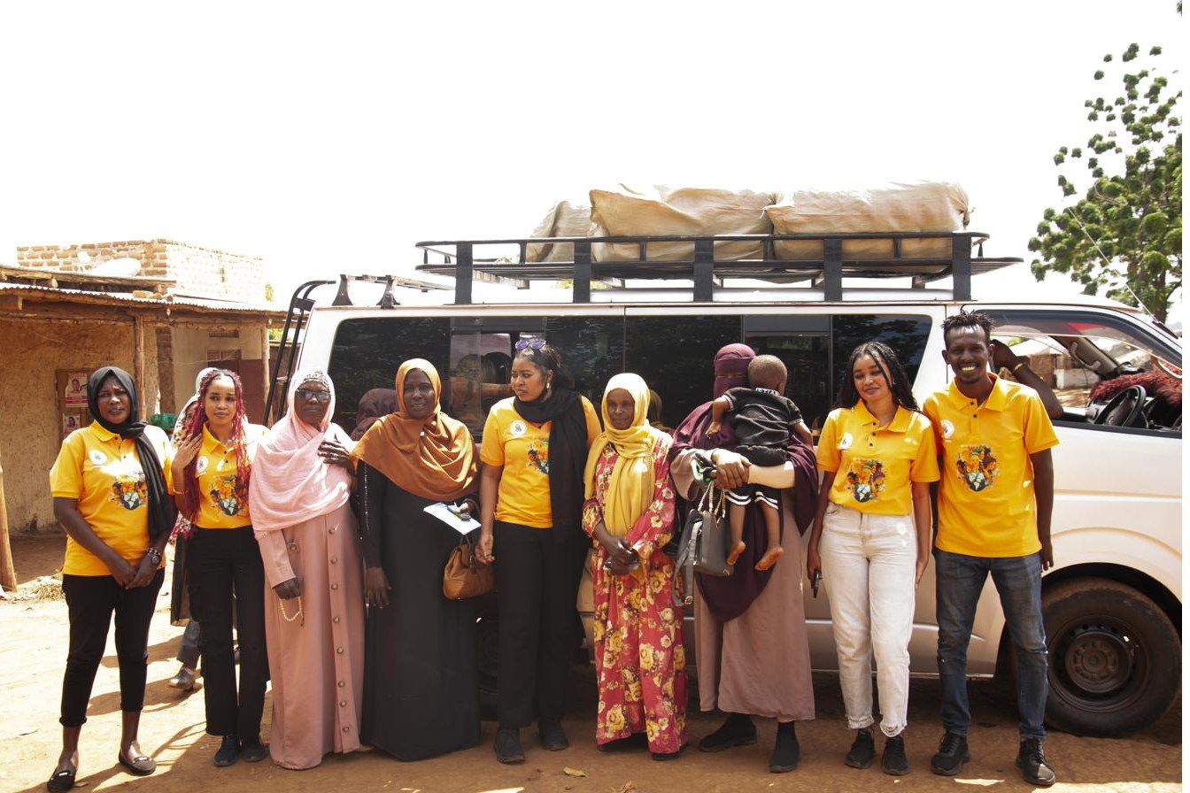 The team standing beside a loaded vehicle before a distribution