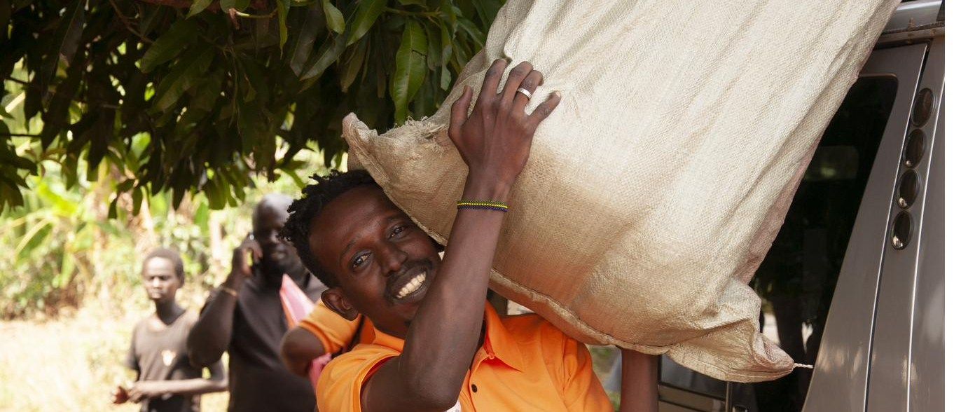 A staff member carrying a sack of supplies on one shoulder
