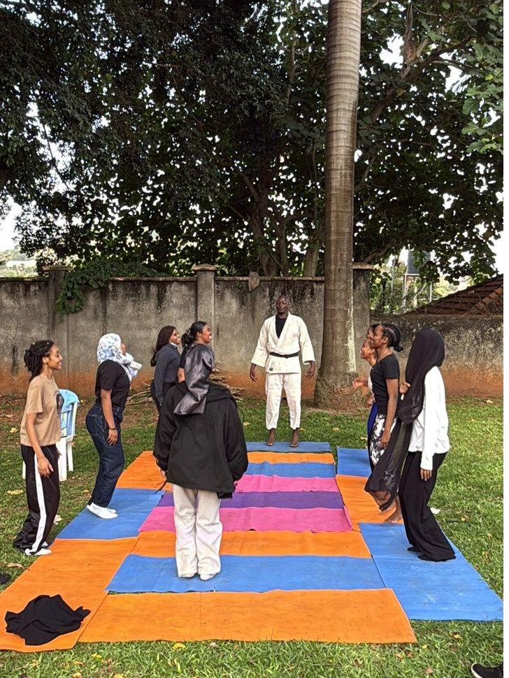 Participants practising movement drills on mats laid out on grass
